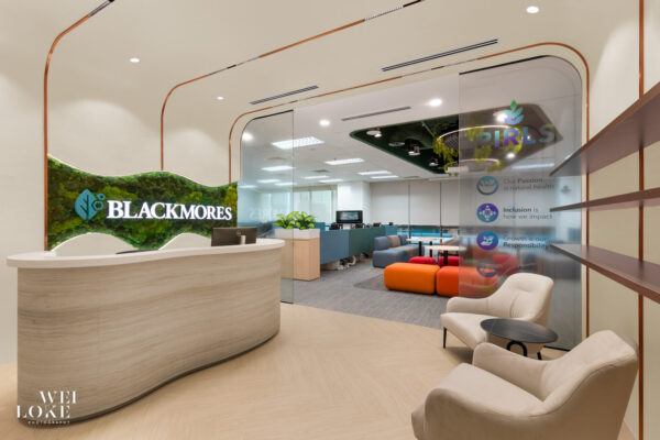Reception area with curved marble counter and green moss wall at Blackmores Malaysia corporate office.