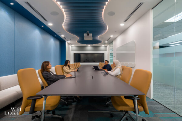 Meeting room with deep blue feature wall and natural tones in Blackmores Malaysia office.