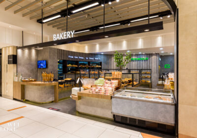 The KLCC outlet presents a moodier tone, using concrete textures and linear lighting for a refined retail presence.